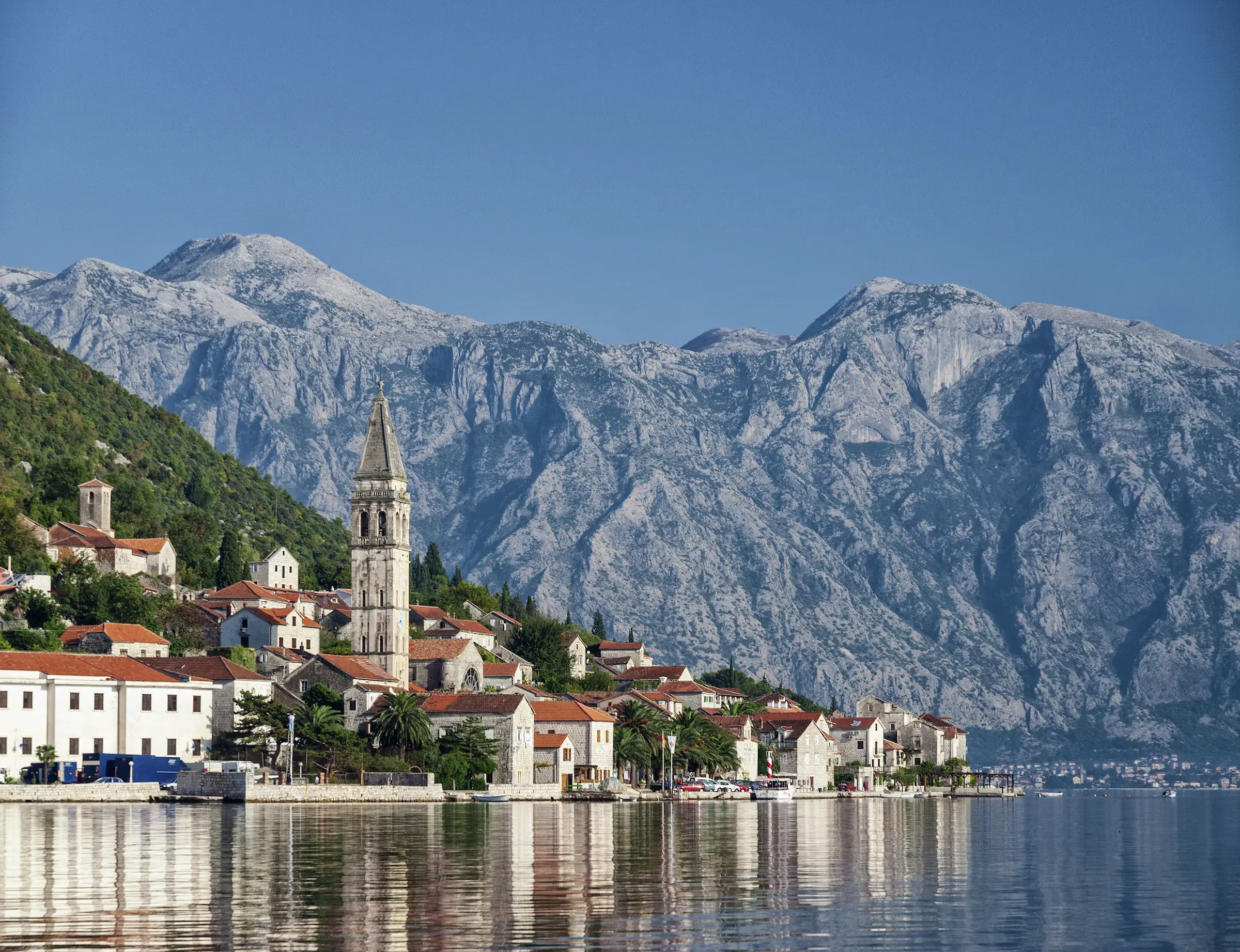 The Perast Mountain range in Montenegro, with a small ocean-side village