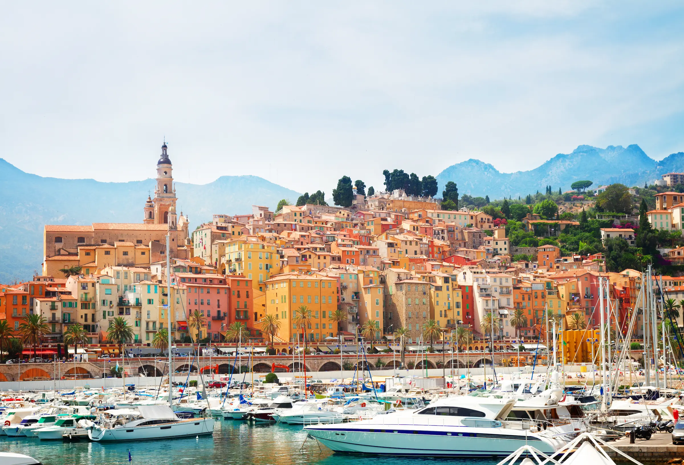 View of French Riviera town with luxury yachts and colourful houses
