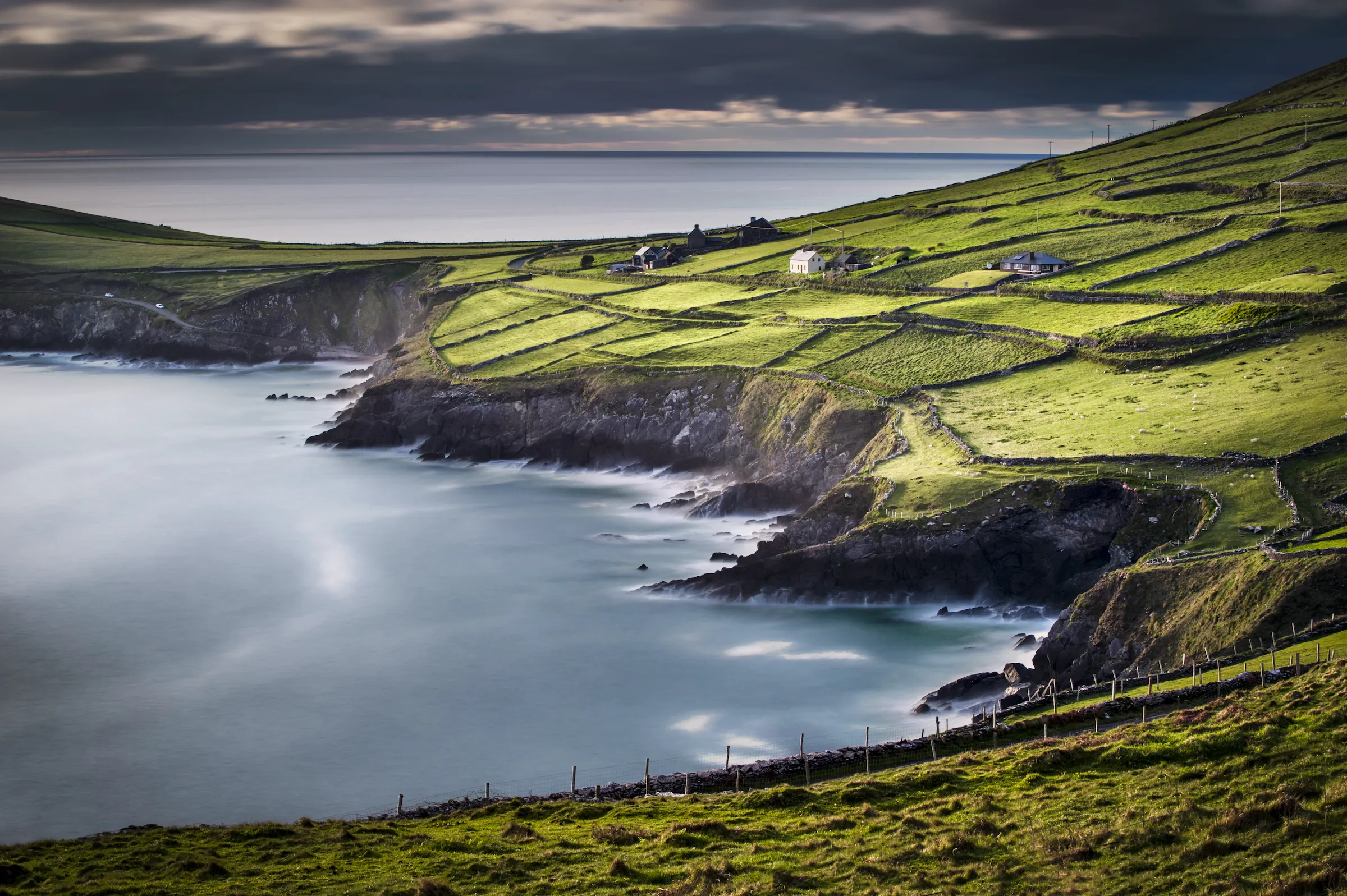 Aerial view of Ireland's west coast with green fields, ocean cliffs and traditional farm cottages — luxury Ireland travel with Eventra Bespoke
